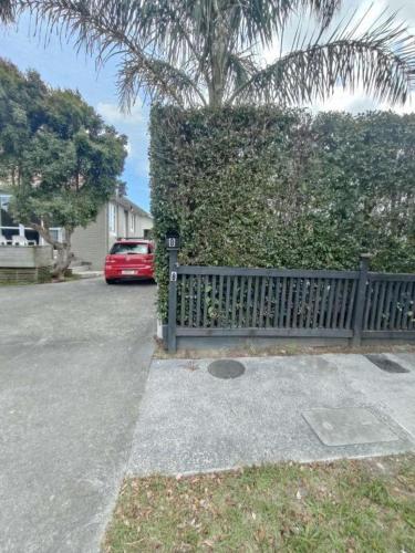 a car parked in a driveway next to a fence at 6 Beds including 4 Double Beds and 2 Single Sofa Beds Serviced Chalet B in Auckland