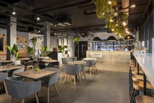 a restaurant with tables and chairs and a bar at Four Points Flex by Sheraton London Shoreditch East in London