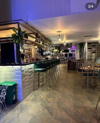 a bar with green bar stools in a restaurant at HOTEL GOLDEN CARTAGO in Cartago