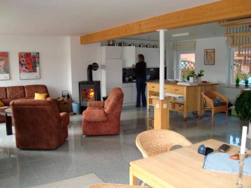 a living room with a person standing in the kitchen at Ferienhaus am Nord-Ostsee-Kanal in Sehestedt