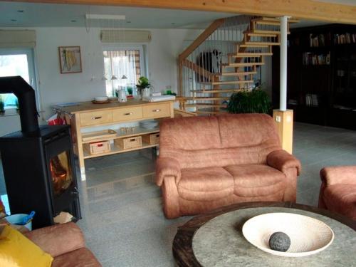 a living room with a couch and a chair and a wood stove at Ferienhaus am Nord-Ostsee-Kanal in Sehestedt