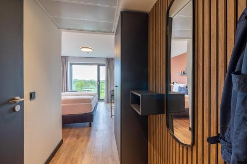 a hotel room with a bed and a mirror at The Base Munich in Munich