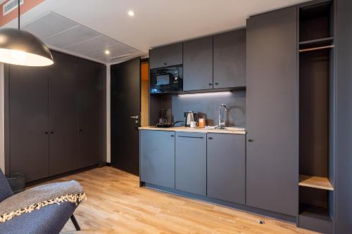 a kitchen with gray cabinets and a counter top at The Base Munich in Munich