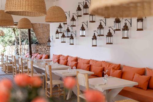 a restaurant with white tables and orange chairs at La Mouette et les Dromadaires in Essaouira