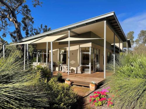 a large house with a porch and a deck at White Tree Retreat Yallingup hills in Yallingup