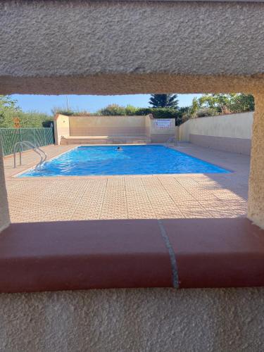 Une fenêtre montre la piscine. dans l'établissement St Cyprien charmant rez de jardin 2 velos Piscine, à Saint-Cyprien