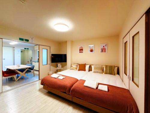 um quarto com uma cama grande e uma sala de estar em 駅徒歩1分2DKで広々快適5階エレベーターなし 天王寺4分心斎橋13分HANAInn em Osaka