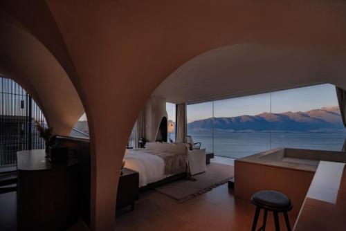 a bedroom with a bed and a view of the mountains at 大理风雅颂苍洱眼酒店-FYS Hotel in Dali