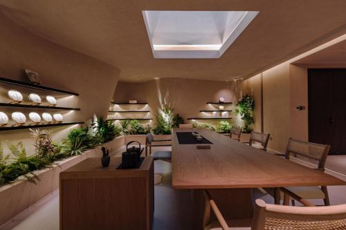 a dining room with a table and some plants at 大理风雅颂苍洱眼酒店-FYS Hotel in Dali