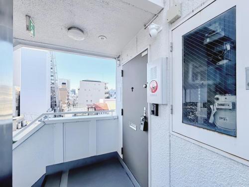 um quarto com uma varanda com vista para a cidade em 駅徒歩1分2DKで広々快適5階エレベーターなし 天王寺4分心斎橋13分HANAInn em Osaka