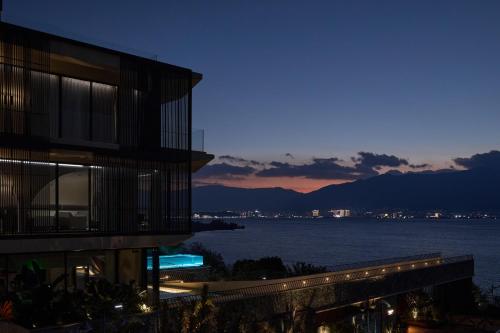 a building with a view of the water at night at 大理风雅颂苍洱眼酒店-FYS Hotel in Dali