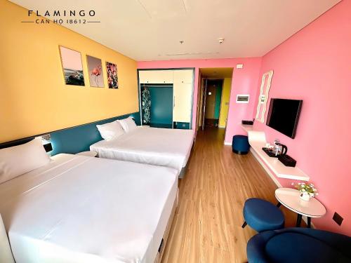 ein Hotelzimmer mit zwei Betten und einem Fernseher in der Unterkunft FLAMINGO IBIZA HAI TIEN - Resort 5 Sao in Thanh Hóa