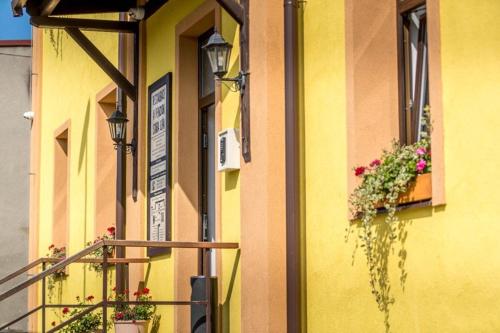 a yellow building with flower boxes and a balcony at Restaurace Stará Lípa in Česká Lípa
