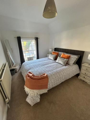 a bedroom with a large bed and a window at Angel Cottage in stunning Arundel in Arundel