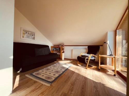 a living room with a black couch and a rug at Arendt in Langholz