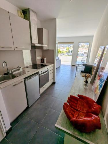 cocina con electrodomésticos blancos y encimera con mesa en Studio spacieux en centre Ville, en Calvi