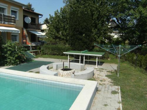 a swimming pool with a ping pong table next to a house at Ferienhaus Nr1 in Balatonszárszó