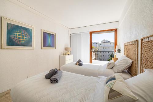 une chambre avec deux lits et une fenêtre dans l'établissement PALM BEACH, sea view apartment, 100m from beaches, à Cannes