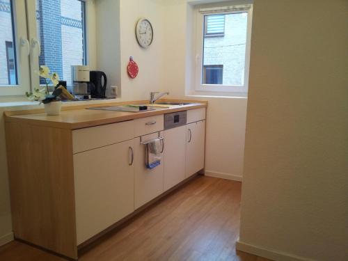 a kitchen with a counter and a sink and two windows at Noorstübchen in Eckernförde