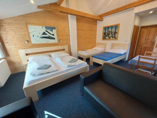 a room with two beds and a couch in it at U Veselé lišky in Hutisko