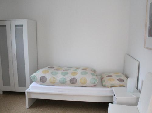 a white bed with two pillows in a room at Haus Roy - Ferienwohnung Erdgeschoß in Zülpich