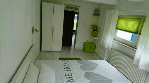 Un dormitorio con una cama y una ventana y una puerta. en Ferienhaus Gerasymchuk, en Eckernförde