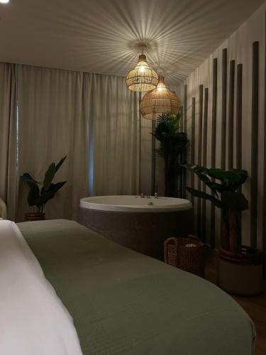 une chambre avec un lit et une baignoire dans l'établissement Love Room Strasbourg, Sauna, Spa, Suite Bali, Évasion Romantique et Sensuelle, à Strasbourg