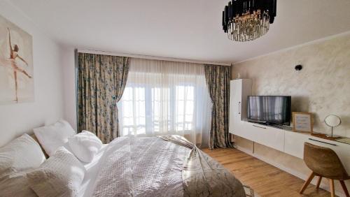 a bedroom with a bed and a tv and a window at Central Modern View AP in Râmnicu Vâlcea