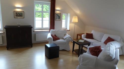 a living room with two white chairs and a table at Galerie D OST in Gingst