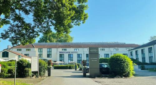 a hotel building with a sign in front of it at Mercure Tagungs- & Landhotel Krefeld in Krefeld
