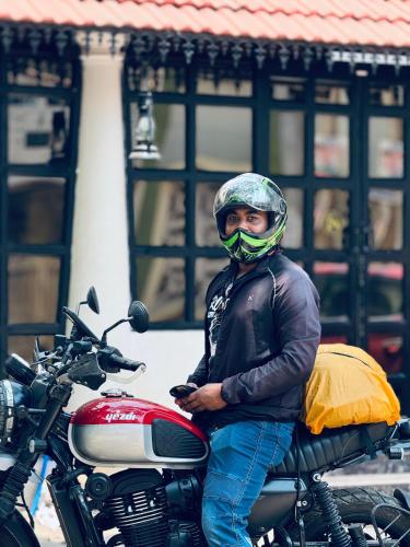 a man is standing next to a motorcycle at David Residency in Madurai