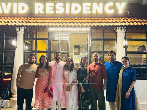 a group of people standing in front of a building at David Residency in Madurai