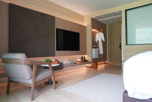 a room with a tv and a chair and a table at Viewpoint Khaoyai Hotel in Mu Si