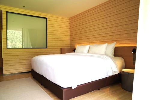 a bedroom with a white bed and a large window at Viewpoint Khaoyai Hotel in Mu Si