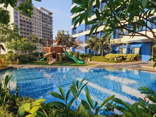 a swimming pool with a playground and a slide at The Air Residences #3724 in Manila