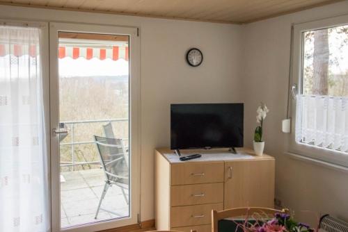 a living room with a tv on a dresser and a window at Ferienhaus Cornell in Amtshof