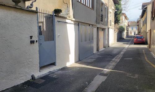 an alley with doors on the side of a building at Le Repos du Mélomane - A 1h de Lyon climatisé in La Côte-Saint-André