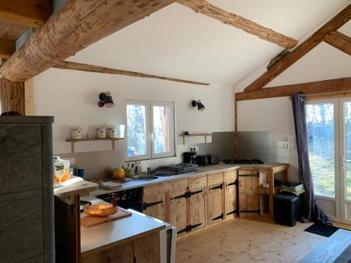 une cuisine avec des placards en bois et une grande fenêtre dans l'établissement Petit chalet en montagne, à Grandrif