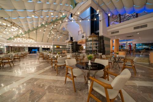 a restaurant with tables and chairs in a building at Hotel Aqua in Marmaris