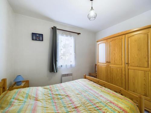 ein Schlafzimmer mit großem Bett und Fenster in der Unterkunft Maison de vacances pour 4, St-Hilaire-de-Riez in Saint-Hilaire-de-Riez