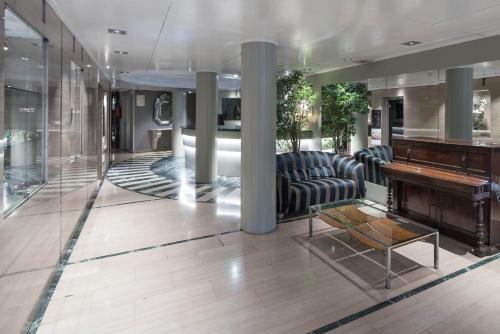 a lobby with a piano and a living room at Catalonia Roma in Barcelona