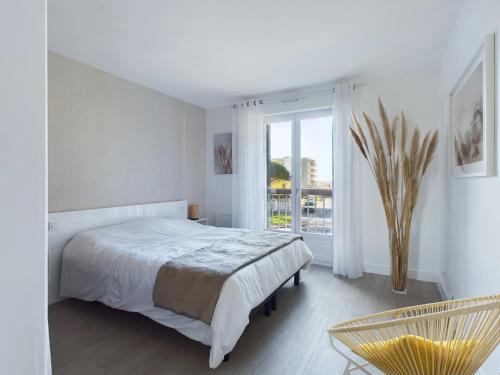 une chambre blanche avec un lit et une fenêtre dans l'établissement Appartement avec balcon vue mer, la Baule, à La Baule-les-Pins