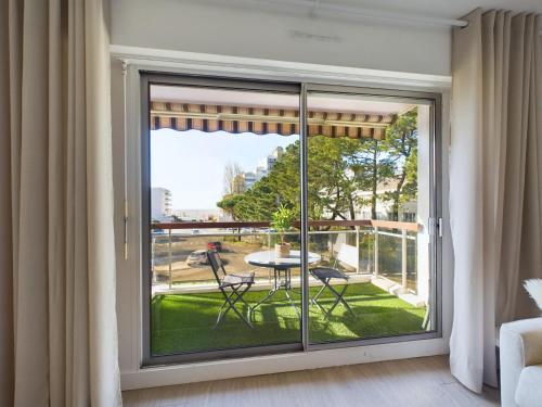 une pièce avec une grande fenêtre avec une table et des chaises dans l'établissement Appartement avec balcon vue mer, la Baule, à La Baule-les-Pins