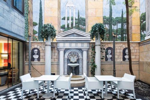 a restaurant with tables and a fountain in front of a building at Catalonia Roma in Barcelona