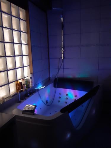 La salle de bains est pourvue d'une baignoire avec un éclairage violet. dans l'établissement Nature et Balnéo en Bourgogne, à Dun-sur-Grandry