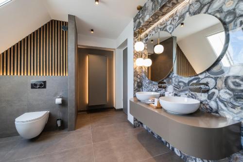 a bathroom with two sinks and a mirror at Riva Prestige Hotel in Szeged