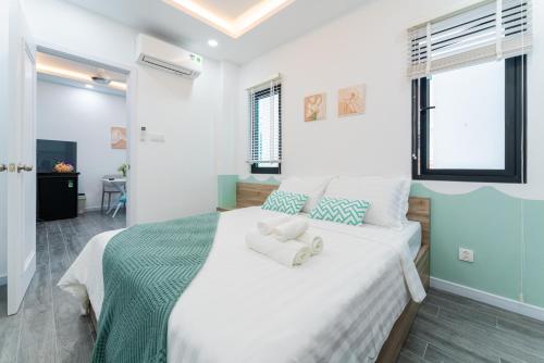 a bedroom with a large white bed with towels on it at ANNIE HOUSE Nha Trang- One bedroom cozy apartment near the beach & Tram Huong Tower with big promo in Nha Trang