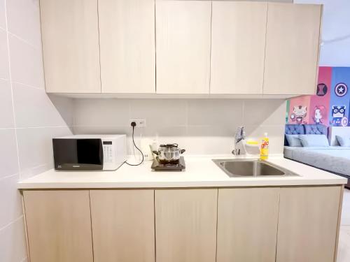 a kitchen with a microwave and a sink at Midhills Genting Highlands in Genting Highlands