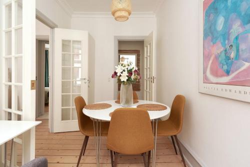 a dining room with a vase of flowers on a table at Family - Central - Sea - Luxury in Copenhagen