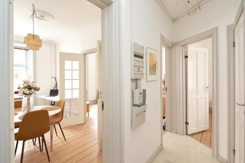 a white kitchen and dining room with a table and chairs at Family - Central - Sea - Luxury in Copenhagen